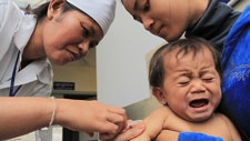 A trained medical staff administers a vaccine on an infant. Preah Vihear province, Cambodia.
